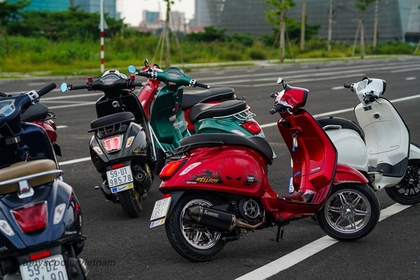 Vespa độ với thiết kế yên đơn, màu đỏ rực rỡ nổi bật giữa phố phường.